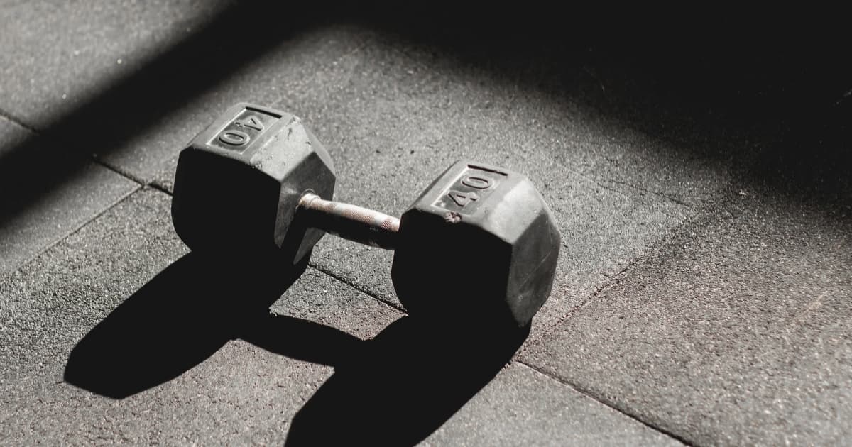 A 40-pound dumbbell on a gym floor representing a planned strength session